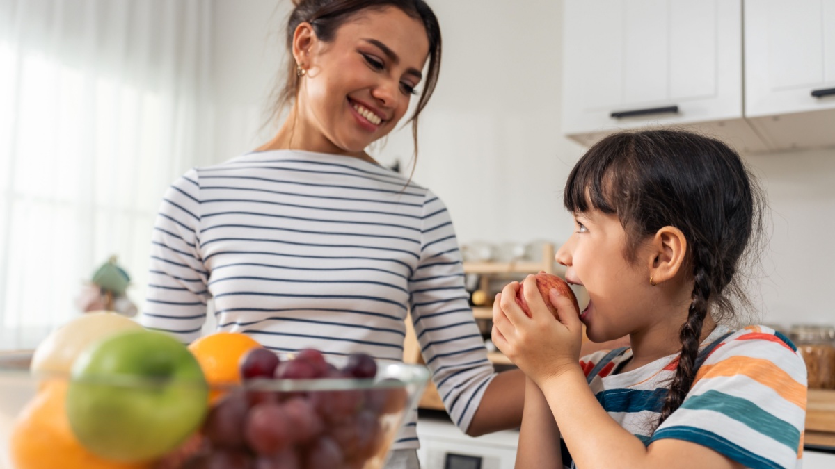 Children eating apples and grapes